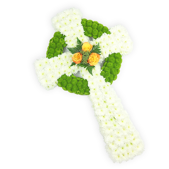 This image shows an elegant, three-dimensional Celtic cross composed entirely of fresh flowers, set on a stark white background and photographed from a slightly elevated viewpoint so the form and textures are clear. The principal mass of the cross - the arms and the extended lower stem - is formed from compact clusters of white spray chrysanthemums, their tiny petals creating a unified, velvety surface that conveys serenity and purity. Bright apple-green button chrysanthemums are woven into the design to define the circular boss at the intersection of the arms and to alternate within the cross's arms, producing a striking pattern of green islands against the white field and enhancing the sculptural depth. At the very centre, a delicate trio of orange roses - rich, sunlit orange with a hint of yellow - provides a warm, tender focal point; these roses are accented by small sprays of dark green foliage or fern, which frame them and add contrast. The overall lighting is soft and even, emphasizing petal detail and the cross's three-dimensionality while keeping the mood composed and respectful. The colourway naturally echoes Irish colours, making this arrangement especially suited to commemorations of Celtic heritage. As a local florist familiar with services in Queensbury, near Queensbury High Street and the churches serving the Kingsbury and Wembley communities, I see this piece as a dignified funeral or memorial tribute: a carefully balanced gesture of memory, faith, and comfort that reads both classical and contemporary in its quiet craftsmanship.