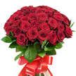 A visually stunning cluster of approximately fifty to sixty deep red roses, densely gathered and artfully arranged by a local Queensbury florist, takes center stage in this floral composition. The roses, ranging from tightly closed buds to lush, open blooms, display velvety, lush petals that subtly shift in tone from ruby to garnet, each infusing the bouquet with richness and depth. Polished, dark green leaves are woven between the blossoms, adding vital contrast and a touch of woodland elegance, evocative of tree-lined walks in Queensbury's neighbourhood parks. The stems are bound meticulously with a broad, gleaming red satin ribbon, knotted into a generous, ornamental bow whose streaming tails give the arrangement a festive, sophisticated air. Soft, natural light bathes the bouquet, enhancing the intricate play of colour and texture found in every petal and leaf. The bouquet radiates romance, passion, and heartfelt warmth-a fitting tribute for grand romantic occasions or important life milestones celebrated in Queensbury. Every element of this arrangement tells a story of devotion and artistry, a gesture meant to make an enduring impression for any memorable occasion.