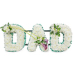 This image presents a dignified funeral flower tribute spelling the word DAD in three generously sized upright letters, meticulously crafted with a florist's precision. Each letter is solidly filled with tightly clustered white chrysanthemums, forming a dense, pillow-like texture that feels soft and comforting, as though each petal carries a shared memory. The flowers are immaculate and bright, their whiteness symbolising purity, respect, and a peaceful farewell. Around the outer edges, an emerald green satin ribbon is pleated into a gentle ruffle, tracing the contours of the letters and providing a clean, vivid outline that enhances the overall shape. Behind the blooms, faint glimpses of a dark supporting frame and horizontal bars suggest a sturdy construction designed to stand beside a coffin, at the front of a chapel, or near a memorial table in Queensbury. The left-hand D features a carefully placed cluster of white freesia and glossy foliage at its upper left curve, bringing a touch of graceful movement and light fragrance. Two long, slim green stems extend diagonally from this area towards the central A, visually linking the letters and leading the eye along the tribute. At the lower right of the A, these stems culminate in an elegant focal spray: two rich, deep purple calla lilies, with their smooth, sculpted trumpets, are nestled among additional white freesia and layered greenery, adding depth, contrast, and a sense of solemn beauty. The final D is topped on its upper right with a smaller matching cluster of freesia and foliage, completing the design with symmetry and care. Overall, the tribute feels like a tender, handcrafted message of love and remembrance from a family in Queensbury to their dearly missed father.
