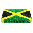 A bold, rectangular sympathy tribute styled after the Jamaican flag fills the frame, its sculpted surface giving the impression of a carefully woven floral tapestry. The entire piece is built from hundreds upon hundreds of small, crumpled petals and flower heads, placed so closely together that the texture appears almost velvety to the touch. Dominating the design is a brilliant golden-yellow diagonal cross that runs from one corner to the other, forming a clear, striking X. These yellow blooms look like tiny bursts of sunshine, their softly curled edges catching the light and adding warmth and optimism to the arrangement. The saltire neatly divides the tribute into four triangular panels. At the top and bottom, dense clusters of lush green flowers echo ideas of growth, renewal, and the green open spaces around Queensbury, from quiet residential gardens to the wide paths leading toward nearby Kingsbury. On the left and right, the triangles are rendered in deep black, their smooth, satiny texture giving the design balance and gravity, appropriate for a farewell that honours both life and legacy. Under bright, even lighting, no single petal is lost in shadow; instead, the interplay of light and dark across the green, gold, and black areas heightens the sense of dimension. The tribute feels substantial, like a commemorative panel that could rest beside a coffin, memorial frame, or photograph at a service in Queensbury. It expresses pride in Jamaican heritage, respect for the departed, and comfort for the family, all conveyed through the language of colour, texture, and florist craftsmanship.