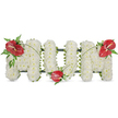 A dignified, freestanding floral tribute spells MUM in bold, three-dimensional capital letters against a clean white background. Each letter is built from hundreds of small, pristine white spray chrysanthemums, densely packed so the surface reads soft, voluminous and cloud-like to the eye and touch; the tiny petals create a quiet, soothing texture that suggests purity and peace. A subtle dark-green support frame peeks out along the edges of each letter, giving the tribute structural definition without breaking the serenity of the white blooms. Three glossy red anthuriums - their heart-shaped spathes deep, tropical red and each with a pale yellowish-white spadix - punctuate the design: one set proudly on the upper left curve of the first M, a second tucked into the base curve of the U, and a third placed on the upper right curve of the final M. Each anthurium sits within small clusters of varied deep-green foliage, from feathery fern fronds to broader leathery leaves, while thin arching blades of green gently connect the red accents and guide the eye across the letters. Under soft, natural daylight the white chrysanthemums seem to glow faintly and the anthuriums take on a luminous, velvety sheen; the overall effect is one of quiet reflection, dignity and enduring love. As a local Queensbury tribute - suitable for a funeral service, wake or graveside - this arrangement carries the familiar craftsmanship of neighbourhood floristry, offering a personal and consoling emblem of remembrance for a dearly loved mother in and around Queensbury and nearby Kingsbury.