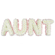 This photograph captures a beautifully composed funeral tribute spelling AUNT in bold, upright letters, each one lush with fresh white chrysanthemums. The blossoms are packed so densely that they form a seamless cushion of petals, their soft, rounded shapes giving the letters a cloud-like volume and a sense of comforting softness. Occasional glimpses of pale yellow at the centres add a natural warmth to the otherwise serene white palette. Running carefully around the outline of every letter is a ruffled light pink satin ribbon, which gently frames the design and introduces a tender, feminine touch. The pink edging clearly defines the silhouette of the word, making it instantly legible, just as it would appear on a hearse or beside a coffin during a service for a beloved aunt in Queensbury. The tribute stands against a bright white background, with even, clear lighting that reveals every texture: the crisp chrysanthemum petals, the sheen of the satin, and the subtle undulation of the floral surface. You can imagine the underlying metal or foam frame, hidden but essential, supporting the fresh flowers so they stay in place during the journey from a local Queensbury home or funeral director to the chapel. Emotionally, the design feels both strong and gentle, combining the solidity of the block lettering with the softness of pastel ribbon and delicate blooms. It is the sort of personalised arrangement a family might choose to honour an aunt who offered quiet guidance and affection, allowing flowers to express their gratitude and remembrance when spoken tributes feel too hard.